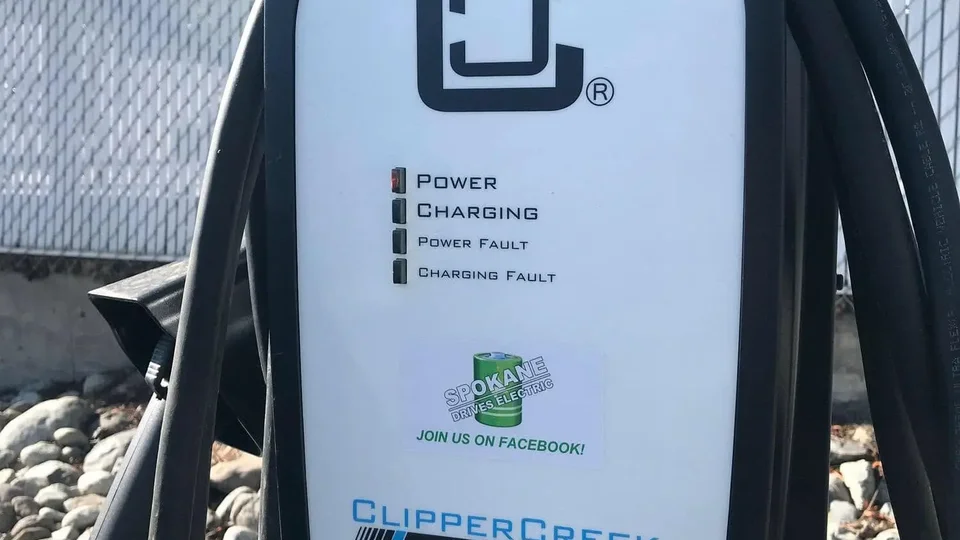 Master electrician comparing hardwired EV charger conduit with heavy-duty NEMA 14-50 plug